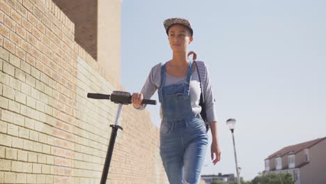 Mixed-race-woman-walking-beside-her-e-scooter