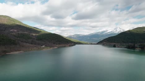 Flying-Above-Waters-of-Doxa-Lake-Greece-between-Pine-Forests,-Aerial-Scenic-Skyline-of-Mountainous-Greek-Hills-Landscape,-Travel-and-Tourism-Destination