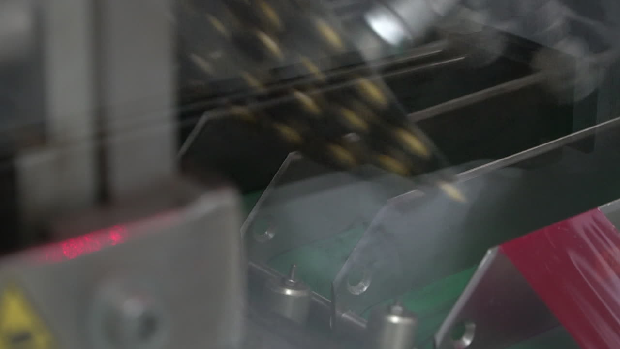 Hydraulic pump machine flips final packaged pills onto conveyor belt, static