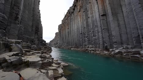 a crystal clear river flowing through magnificent studlagil cliffs in iceland