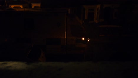 an ambient bedroom window night shot of an ambulance siren parked on a typical british street