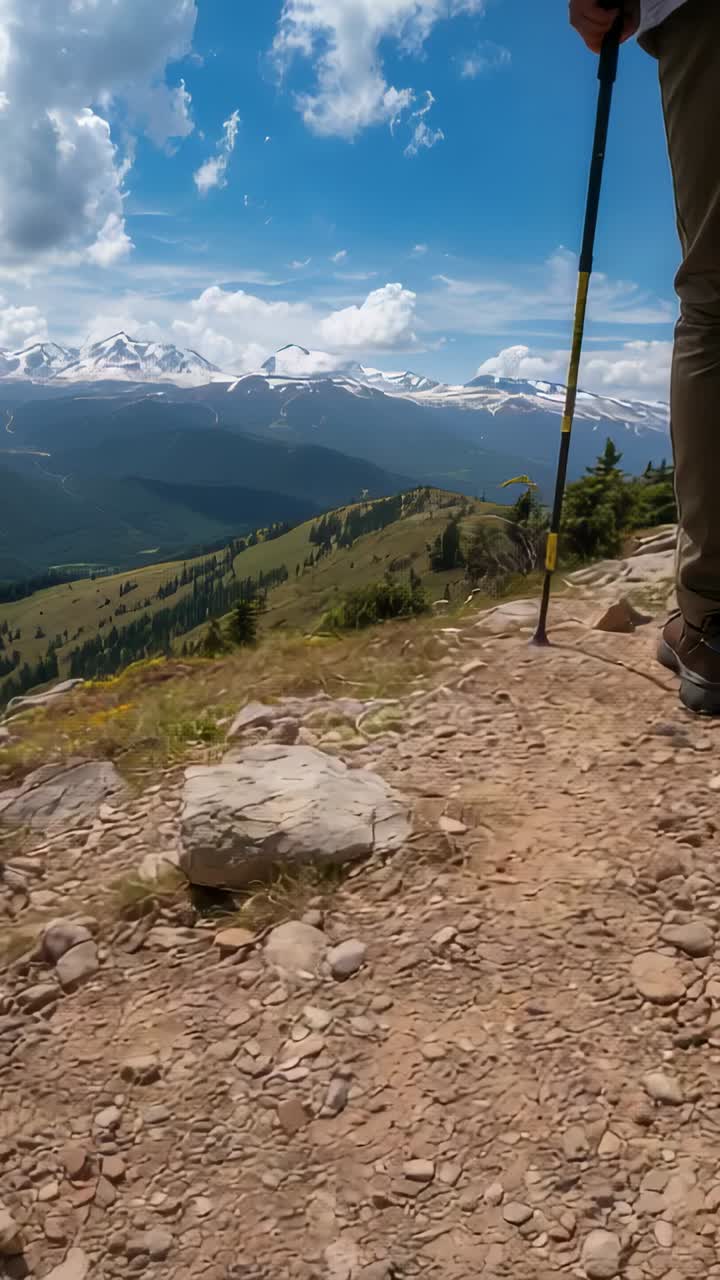 Vertical video: Stepping onto rocky trail, lone hiker navigating stones with yellow-and-black pole