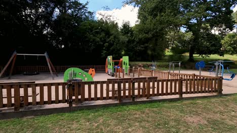 park with playgrounds for children and appliances for seniors who want to feel active and healthy on a sunny summer day near the trees, shot to the left