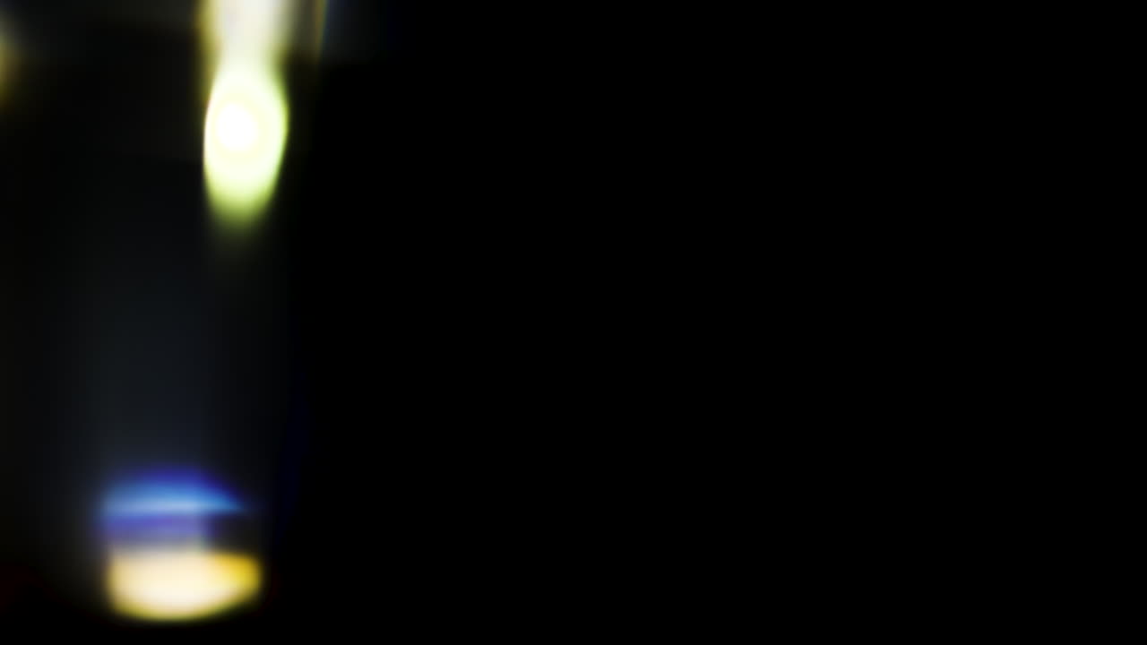 Beautiful, stunning light reflections and anamorphic blue streaks shot on black with high-end cinema anamorphic lens as a background, light leak overlays or transitions for editors