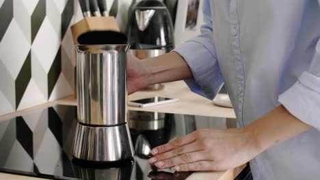 Woman-pouring-herself-a-mug-of-black-coffee-in-kitchen