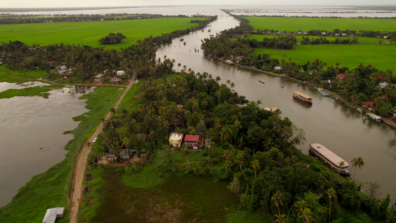 ascenso de drones que revela casas flotantes navegando por el río en kumarakom, kerala, india
