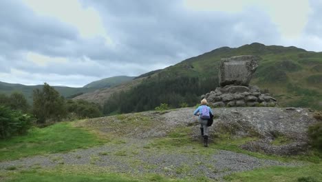 walker approaches the bruce's stone and reads the inscription