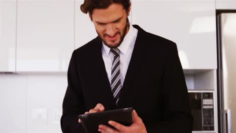 hombre de negocios usando una tableta digital en la cocina