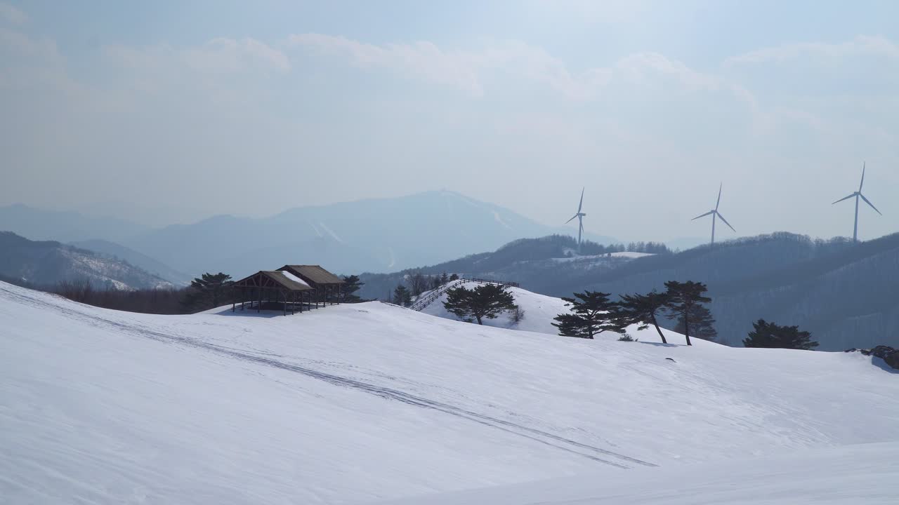 풍력 발전소는 한국의 눈 덮인 산에서 볼 수 있습니다.