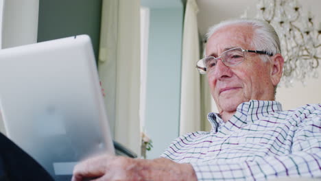 happy senior man using tablet computer at home, close up