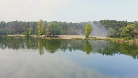 smoke in a coniferous forest after fire near lake