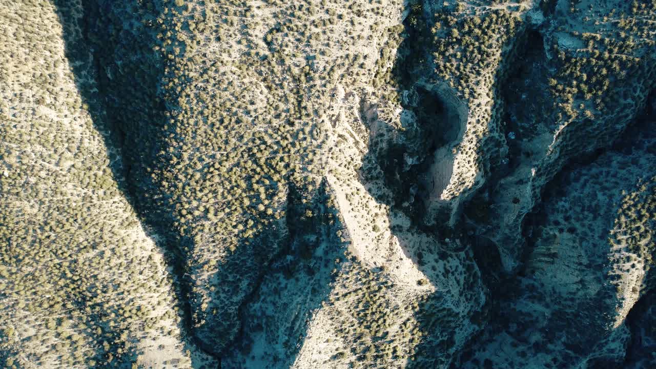 Aerial View of Arid Desert Landscape with Mountains and Shadows