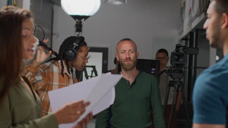 actores con guiones en ensayo rodando una película o video en el estudio con cámara de película y equipo de sonido en el fondo
