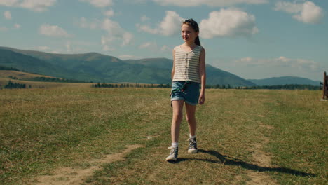 young girl photographer walking with camera young photographer walking with camera on grass hill girl watching at beautiful landscape and amazing nature view spending leisure time outdoor slow motion front view