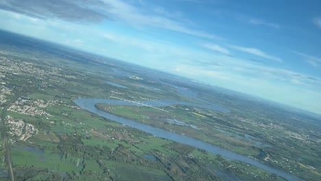 Aerial-view-from-an-airplane-cabin-of-the-Garonne-river-near-Bordeaux,-France,-with-the-river-mouth-ahead