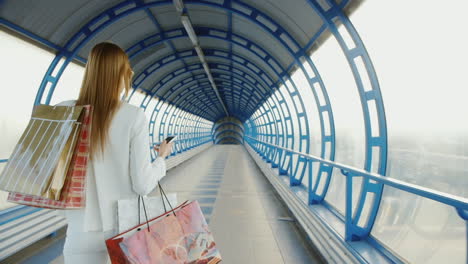 una mujer elegante viene con bolsas de compras hablando por teléfono con un concepto de compra exitoso