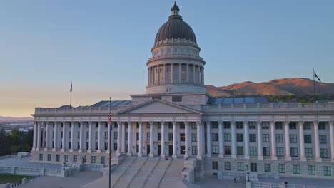 primer plano panorámico de drones del edificio del capitolio del estado de utah mientras el sol se pone sobre salt lake city