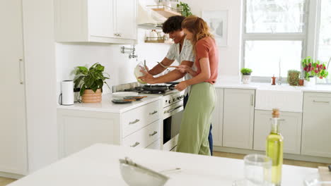 diverse couple cooking together in modern kitchen, mixing ingredients with joy, at home