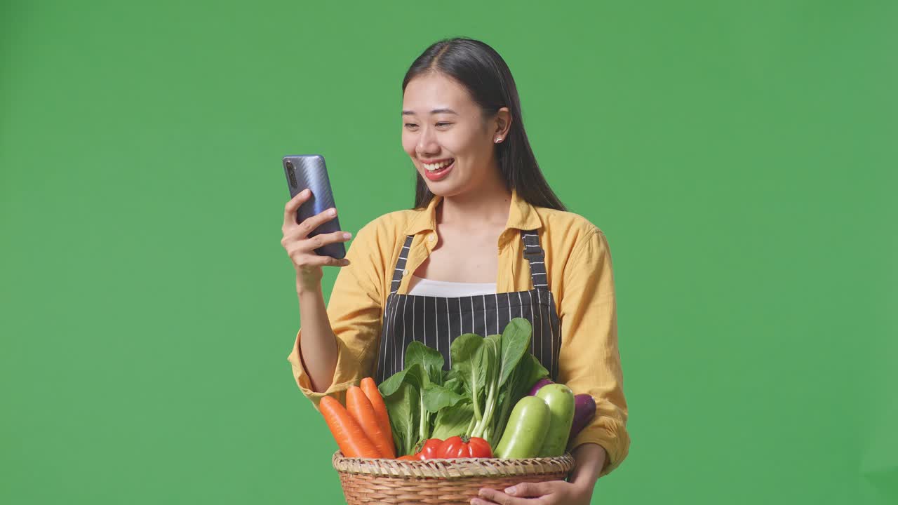 채소 를 가진 여자 가 전화 를 보고 있다
