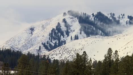 wispy low clouds on snow mountains of boise national forest in idaho, usa