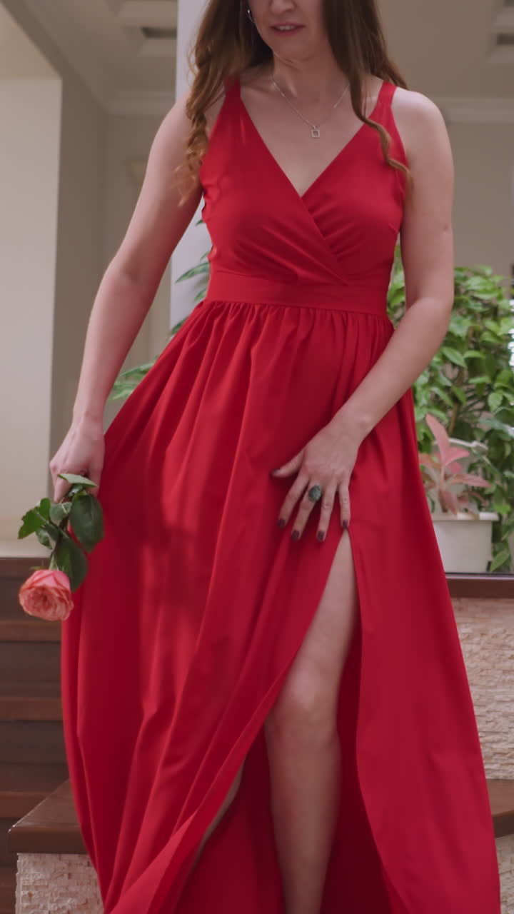 여성 모델은 손에 장미를 들고 앉아있다. 은 드레스를 입은 젊은 여성은 예술 스튜디오에서 전문 예술가에게 포즈를 준비한다.