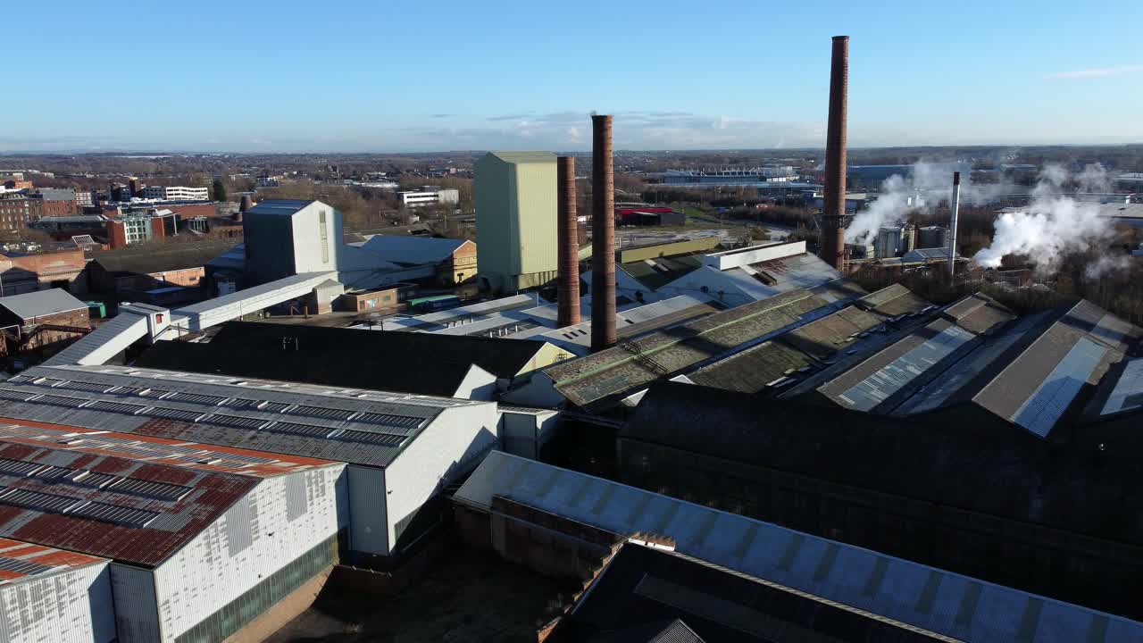 Pilkington glass factory warehouse buildings aerial view dolly left across industrial town manufacturing facility