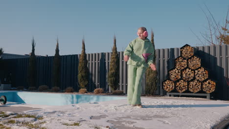 woman dancing in winter garden near pool