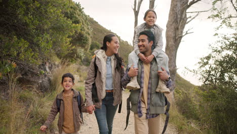 familia feliz, caminando y tomándose de la mano en el bosque