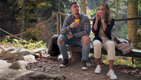 couple relaxing on a hiking trail in autumn forest