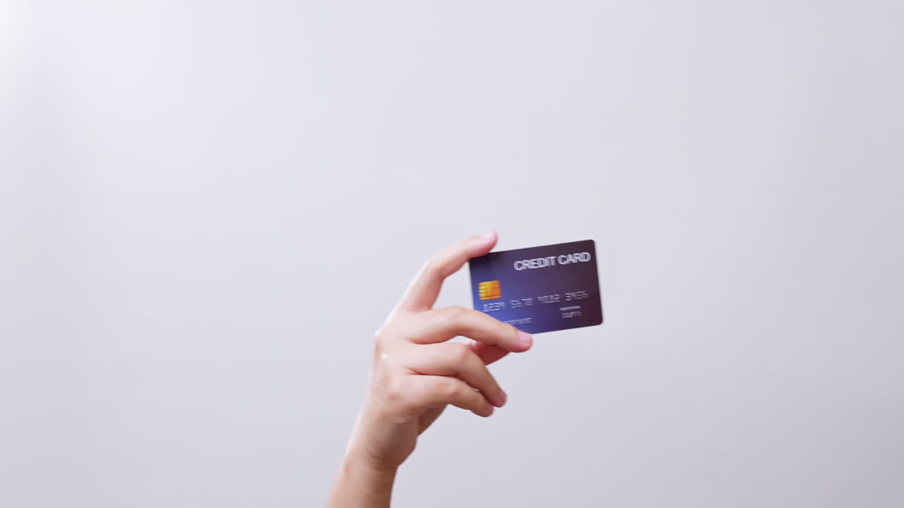Woman's hand shows a credit card ready for shopping online in white studio background with copy space