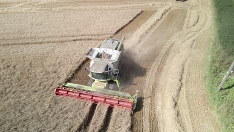 aerial footage of a combine harvester and tractor harvesting a wheat crop