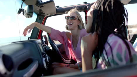 una joven afroamericana y una joven caucásica disfrutan de un viaje soleado en un viaje por carretera.