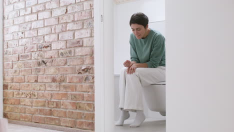 woman with pregnancy test on bathroom