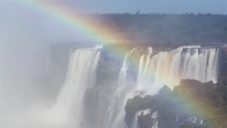cataratas del iguazú de lapso de tiempo y un arco iris cruzando el marco de una esquina a la otra