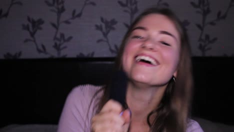 hermosa adolescente cantando al micrófono y bailando en su habitación