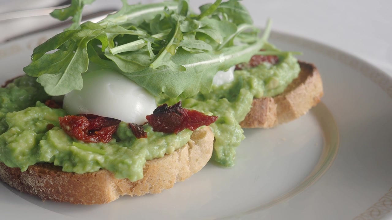 Avocado Toast con uovo in camicia e rucola su un piatto