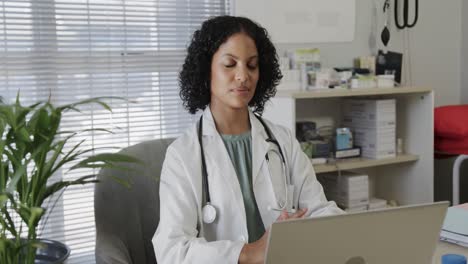 Portrait-of-biracial-female-doctor-wearing-lab-coat,-talking-on-smartphone,-copy-space,-slow-motion