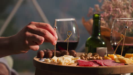 a man enjoying a charcuterie board with red wine