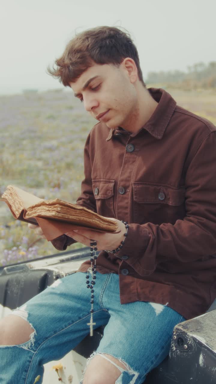 Man Opening The Bible Book And Starting A Prayer On The Shore