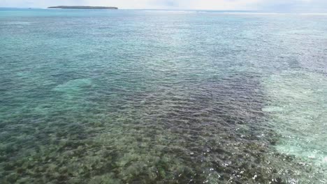 Aerial-forward-tracking-view-of-clear-waters-with-coral-reefs-in-Asia
