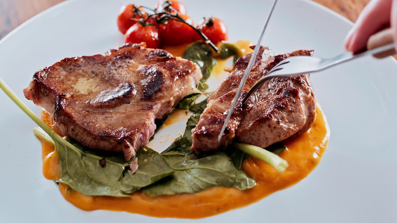 Delicious steak dish being cut with a fork and knife