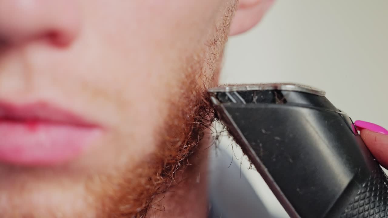Close Up Slow Motion Scene Showing Red Beard Trimmed by Hair Clipper Carefully