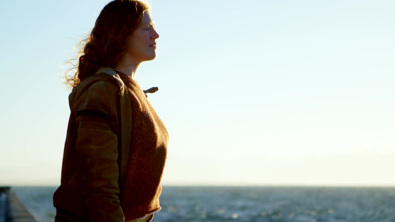 mujer de pie con los brazos extendidos en la playa 4k