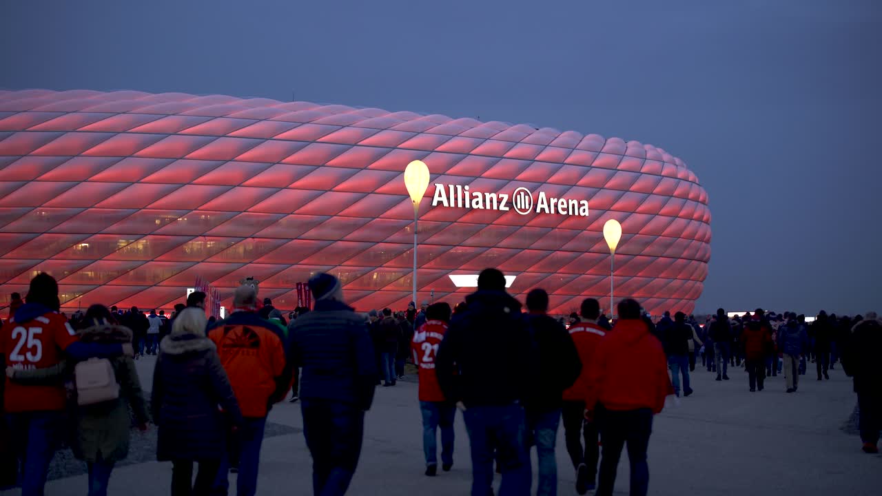Fans walking to Allianz Arena, home stadium of famous german football club FC Bayern München to see a soccer match.