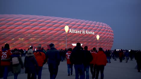 fans walking to allianz arena, home stadium of famous german football club fc bayern münchen to see a soccer match.