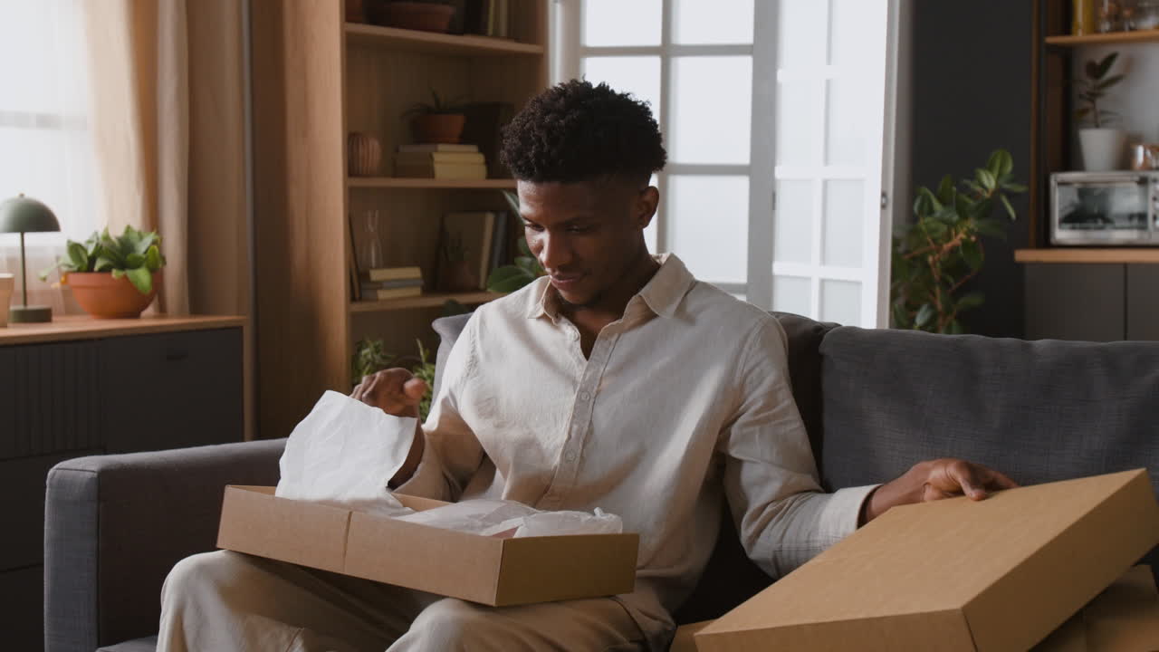 Man opening a box on a sofa
