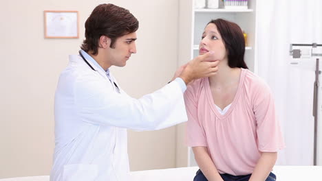 un médico tocando las glándulas de un paciente