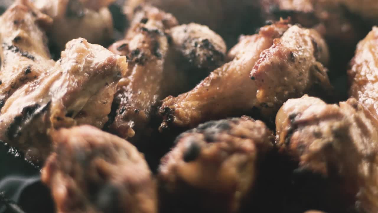 primer plano en cámara lenta de alitas de pollo y humo de la parrilla de carbón
