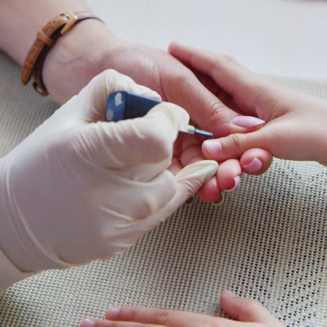 mujer pinta uñas de niños en el salón