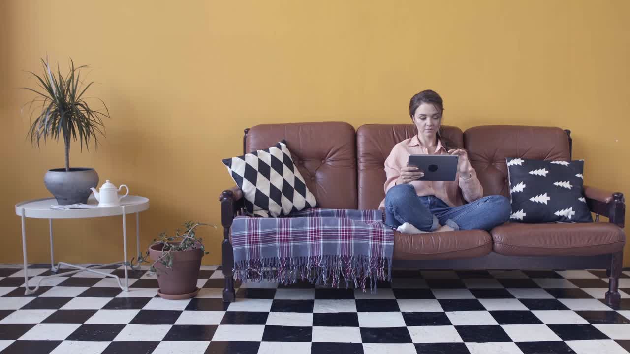 mujer relajándose en el sofá usando una tableta